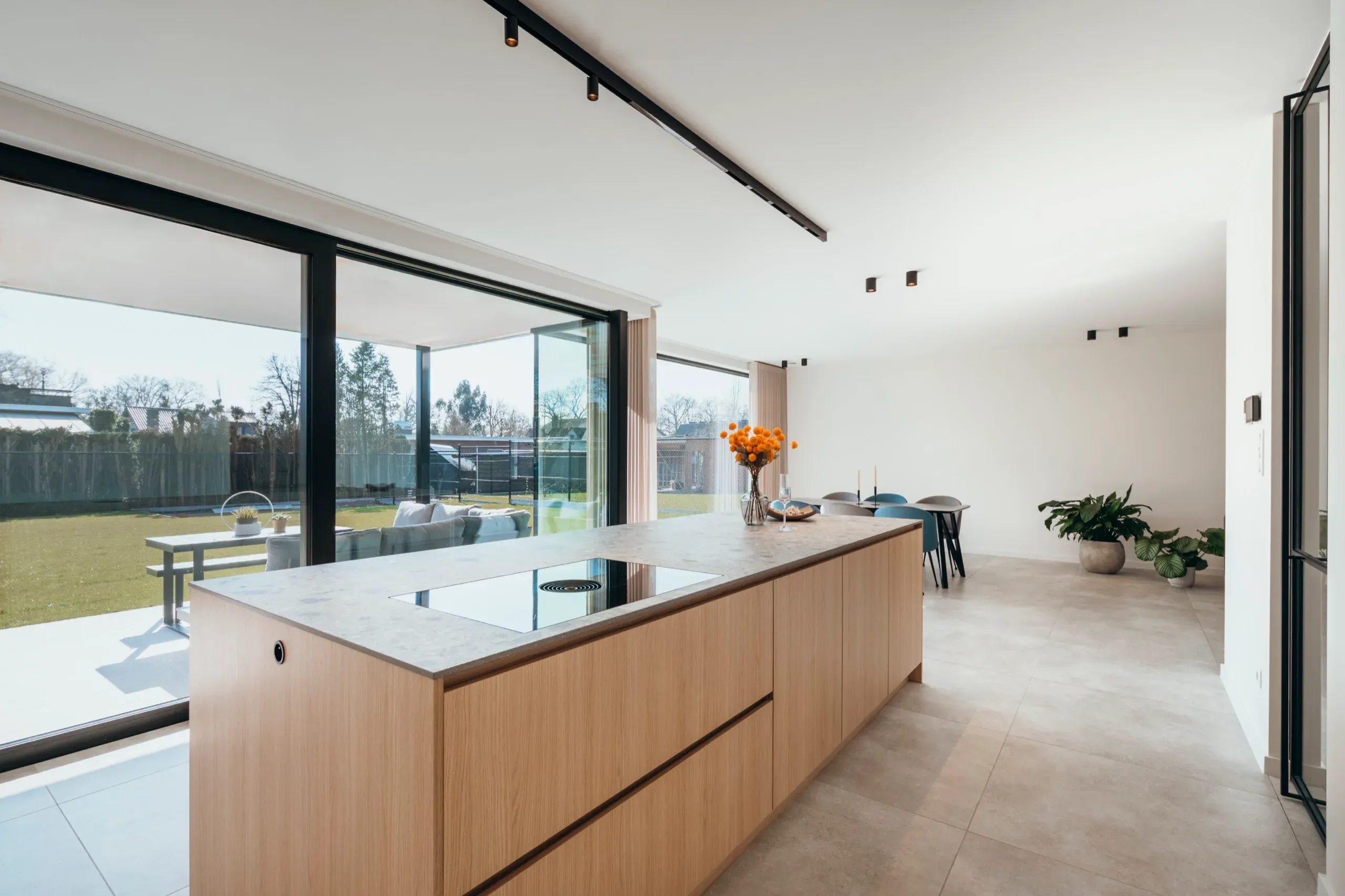 Eiken kookeiland met zicht op de tuin door grote schuiframen